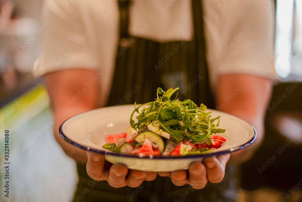 Waiter holding fresh vegetable organic salad, ready to serve. Vegan healthy diet, vegetarian food. Waiter holding fresh vegetable organic salad, ready to serve. Vegan healthy diet, vegetarian food.