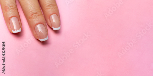 female fingers with beautiful manicure on a pink background. high resolution widescreen image. copy space