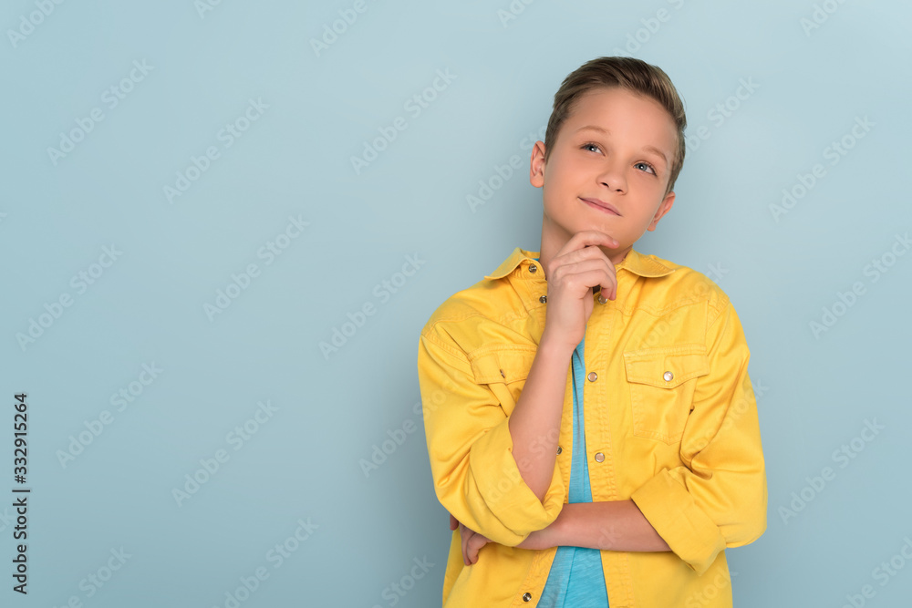 thoughtful kid looking up on blue background with copy space thoughtful kid looking up on blue background with copy space