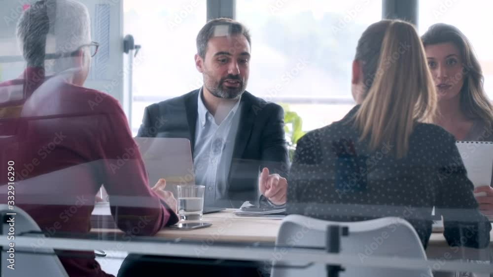 Video of business people discussing together in conference room during meeting at office.