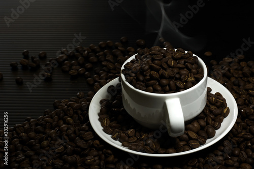 Coffee beans in a white coffee cup in a black background
