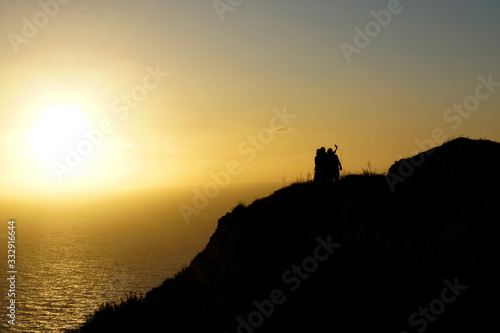  A group of people taking a selfie during sunset on their holiday by the cliff in Malta