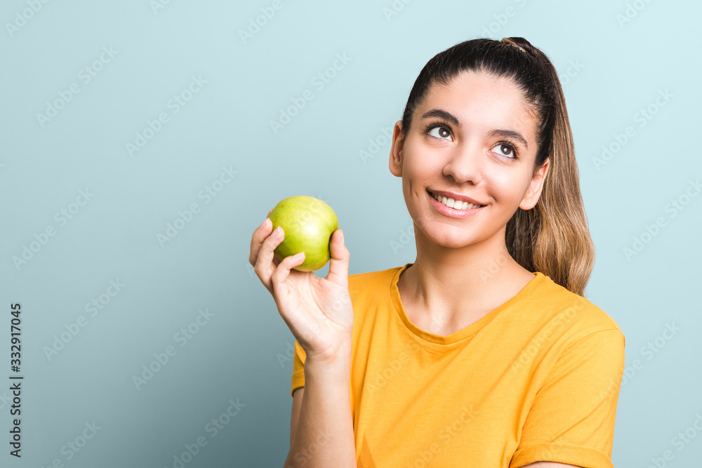 beautiful girl in yellow t-shirt holding green apple in palm with copy space. idea design beautiful girl in yellow t-shirt holding green apple in palm with copy space. idea design