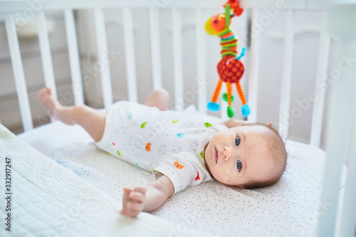 Adorable baby girl lying in the crib photo