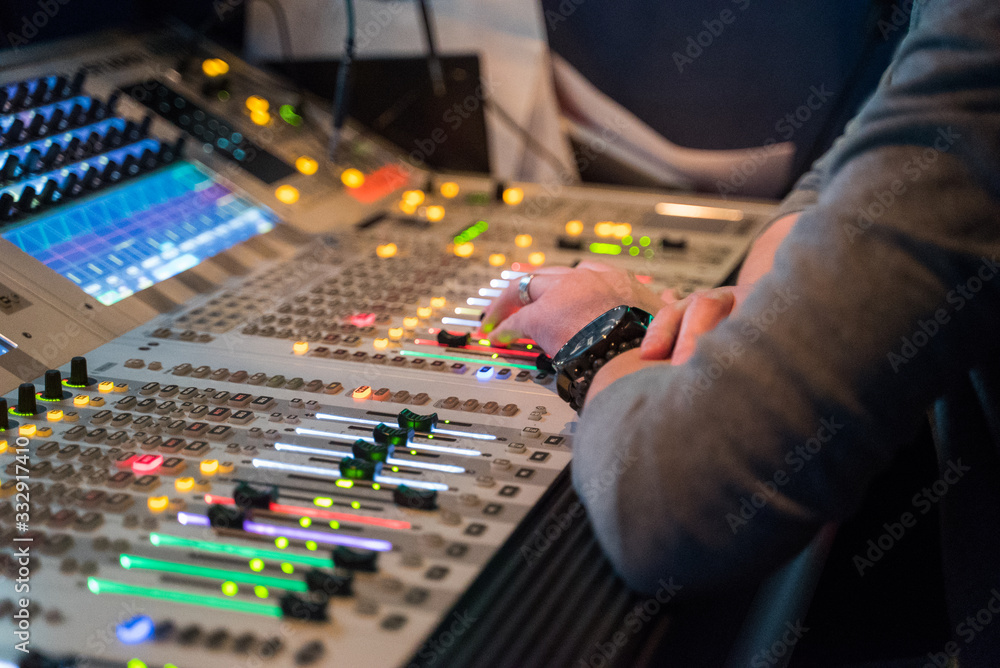Working sound engineer hand on a audio mixer panel during broadcasting concert Working sound engineer hand on a audio mixer panel during broadcasting concert