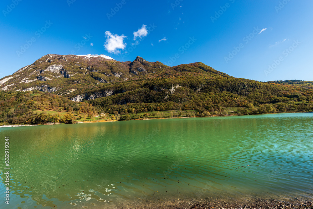 Lago di Tenno, small Alpine lake in Trentino-Alto Adige, with mountains in autumn (Monte Misone). Trento province, Italy, Europe