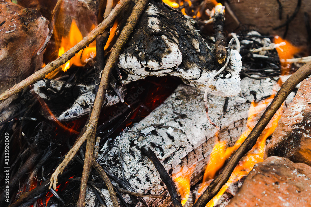 Burning wood (fire, coals and smoke). Lighting a fire from wooden logs and branches in a homemade barbecue made of bricks for cooking barbecue close up Burning wood (fire, coals and smoke). Lighting a fire from wooden logs and branches in a homemade barbecue made of bricks for cooking barbecue close up