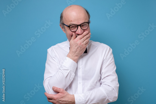 Senior man laughing and embarrassed giggle covering mouth with hands