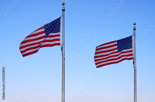 American flag of the United States of America floating in the sky on a mast