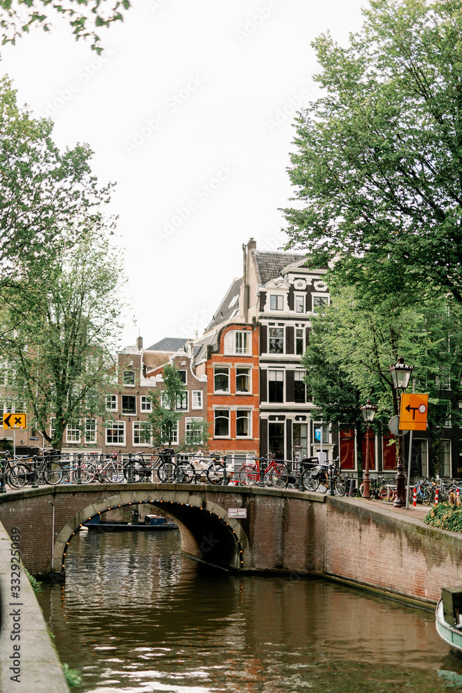 Naklejka premium canal in amsterdam with boats and around old houses