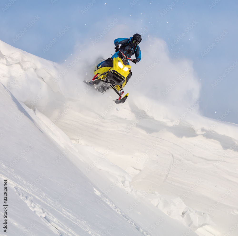 jump on a mountain snowmobile from a high ledge with the descent of a large avalanche. snowmobilers sports riding. Winter extreme. testing of a new model of mountain snowmobile, prototype 2021