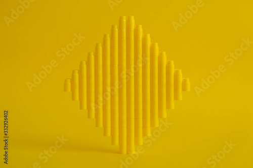 Yellow plastic building blocks in the shape of a cube on yellow background. Background of plastic details building blocks. Parts of bright small spare parts for toys. Copy  empty space for text