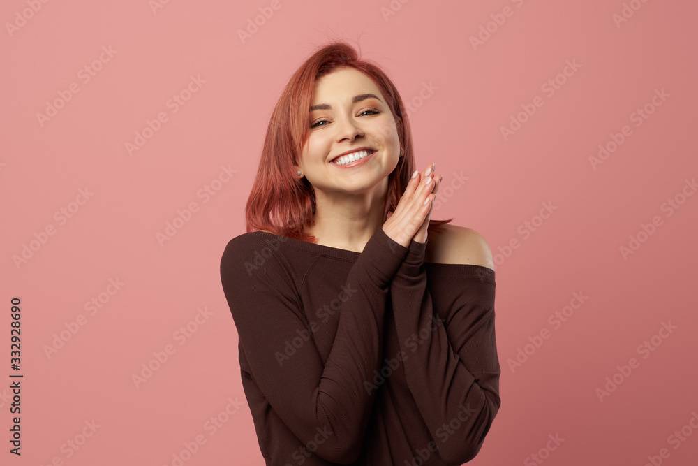 Happy ginger girl in burgundy sweater isolated on empty pink background Happy ginger girl in burgundy sweater isolated on empty pink background