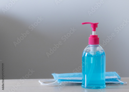 The blue alcohol gel bottle is placed on the right side with the mask. On the table and the white wall Alcohol Hand washing Anti-virus and anti-virus Covid-19 Copy space