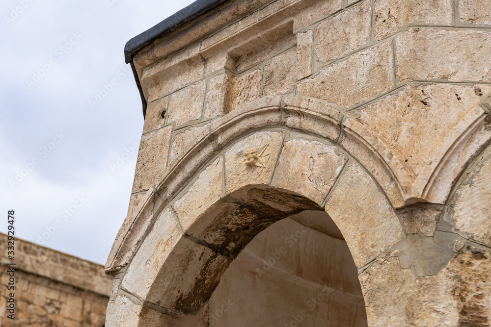 Naklejka premium Decorative decoration carved from stone on the wall of the Dome of the Spirits on the Temple Mount in the Old Town of Jerusalem in Israel