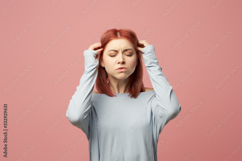Sad ginger woman with closed eyes standing in studio Sad ginger woman with closed eyes standing in studio