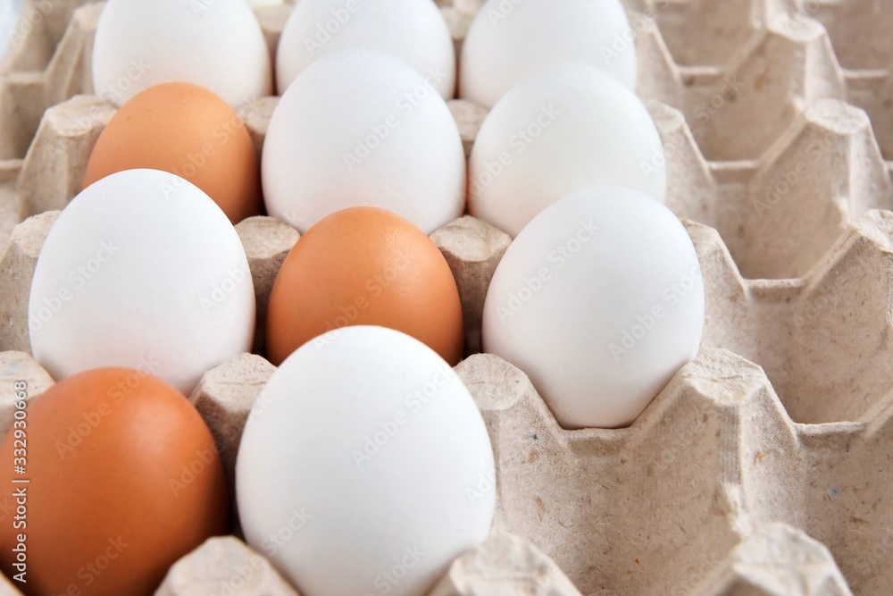 Brown and white chicken eggs in cardboard egg tray. Organic egg for healthy protein breakfast. Easter symbol. Raw chicken eggs. Brown and white chicken eggs in cardboard egg tray. Organic egg for healthy protein breakfast. Easter symbol. Raw chicken eggs.