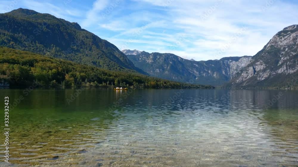 People rafting at Bohinj lake in Slovenian of Triglav National Park. Bohinj Valley of the Julian Alps. Picturesque view, autumn landscape People rafting at Bohinj lake in Slovenian of Triglav National Park. Bohinj Valley of the Julian Alps. Picturesque view, autumn landscape