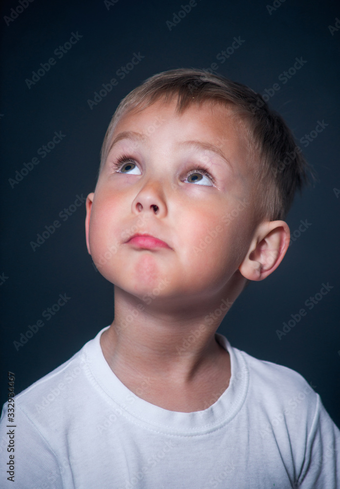 the boy is thoughtful and looks up the boy is thoughtful and looks up