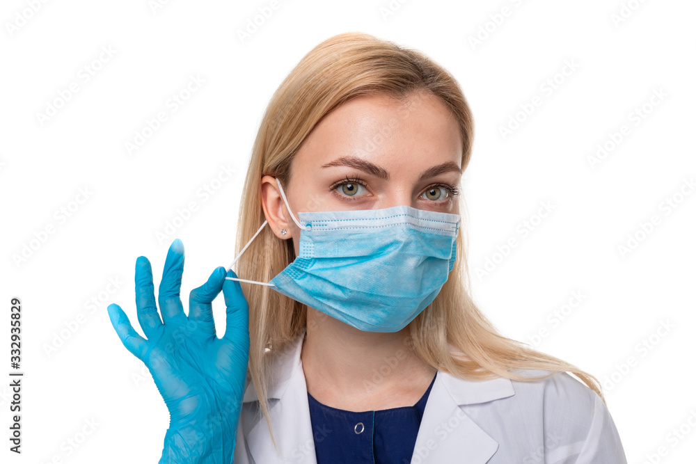 Portrait of a doctor in a protective mask and gloves on a white background. The concept of preventing the spread of the virus Portrait of a doctor in a protective mask and gloves on a white background. The concept of preventing the spread of the virus