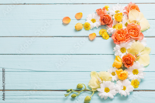 beautiful flowers on blue painted wooden background