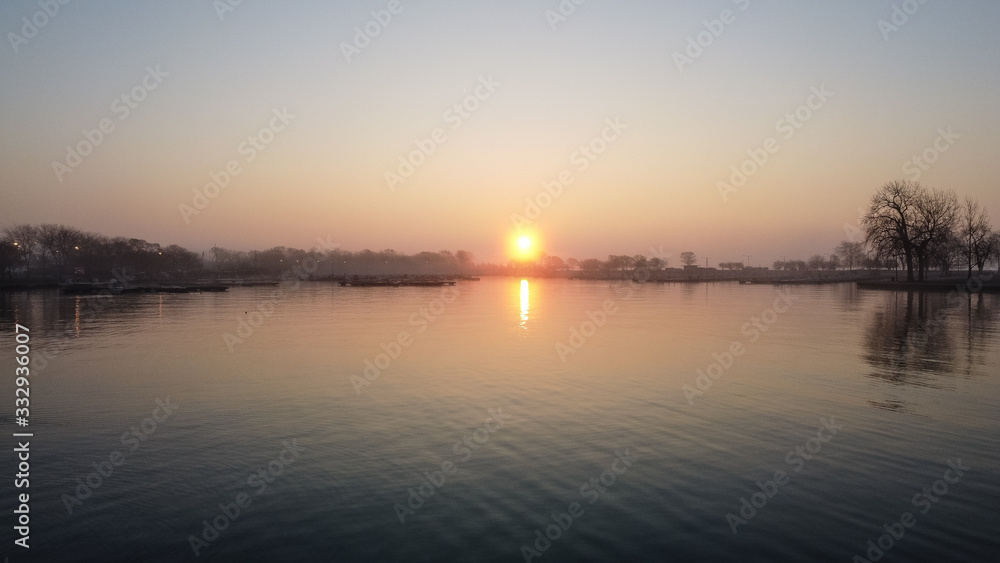 Gorgeous wide angle shot of sun rising over lake harbor early in the morning in Chicago Illinois