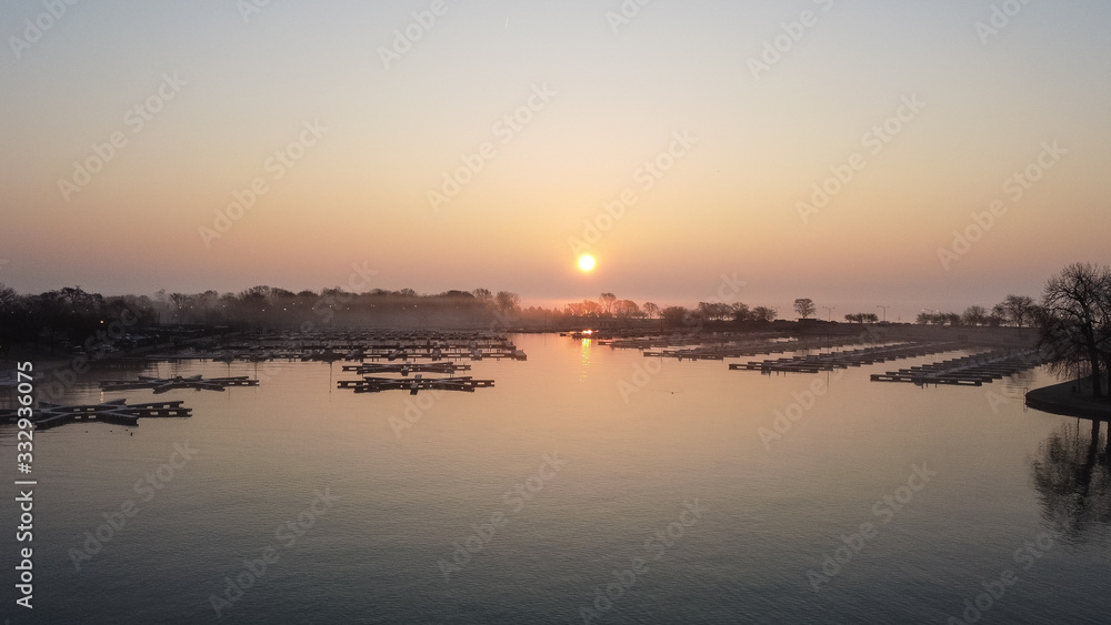Gorgeous wide angle shot of empty boat docks with early morning sunrise and fog in Chicago Illinois
