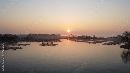 Gorgeous wide angle shot of empty boat docks with early morning sunrise and fog in Chicago Illinois © Richard