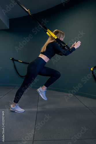 Young woman doing workout on straps