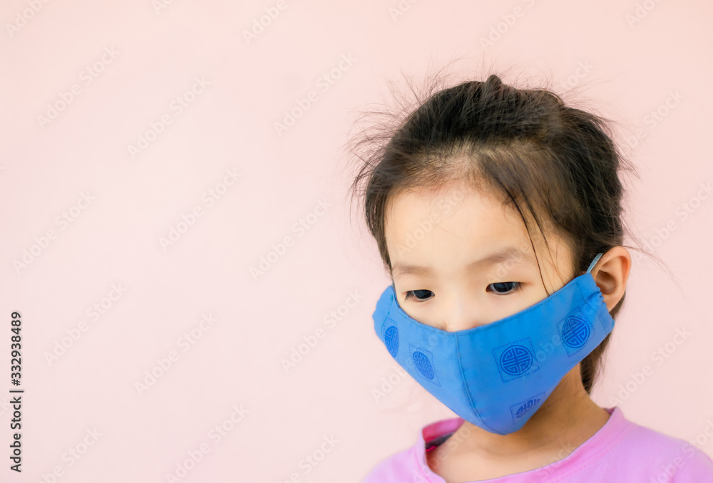 An Asian girl wearing a pink T-shirt stands wearing a sanitary mask. An Asian girl wearing a pink T-shirt stands wearing a sanitary mask.