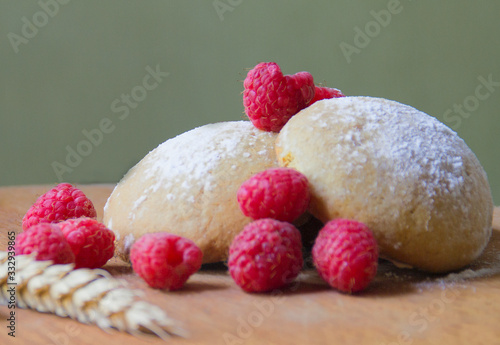 cookies and fresh raspberries on a light green background