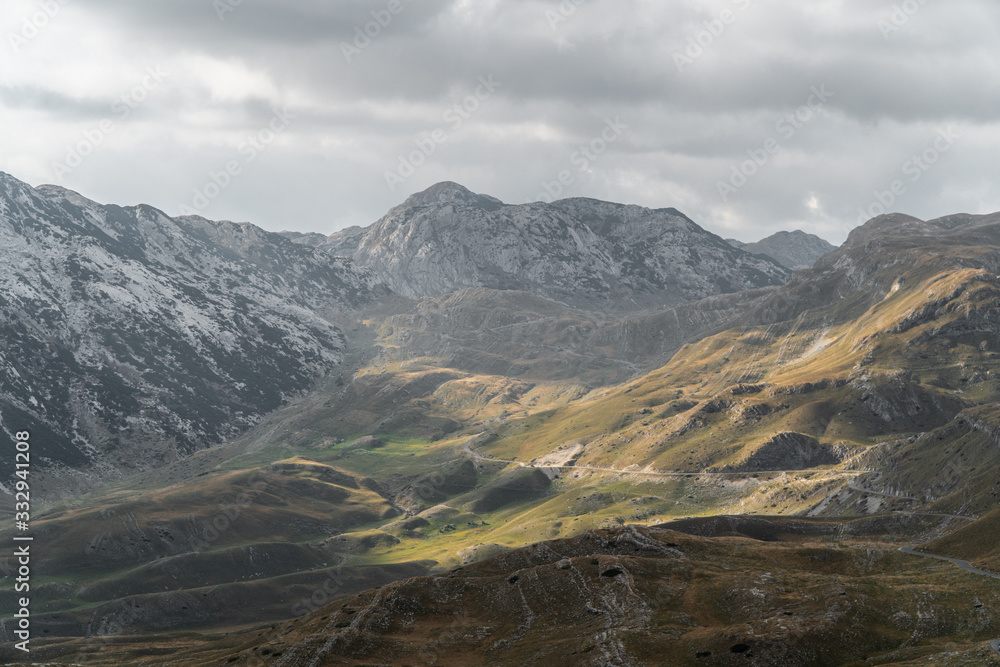 Scenic view of the mountains. Mountain road meanders between the hills. Background Scenic view of the mountains. Mountain road meanders between the hills. Background