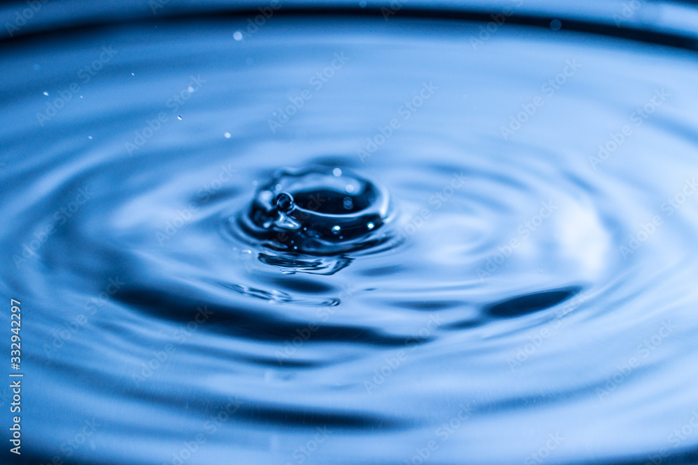 water drop splash in a glass blue colored water drop splash in a glass blue colored