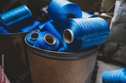 Behälter mit Resten blauer Garnrollen für die Textilindustrie