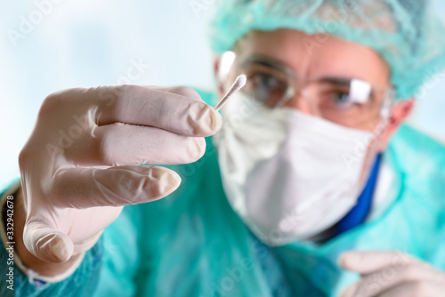 Medical person with protection taking sample with a cotton swab
