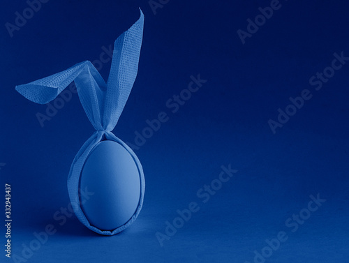 Easter egg with ears on a blue background. toned in modern trendy color classic blue