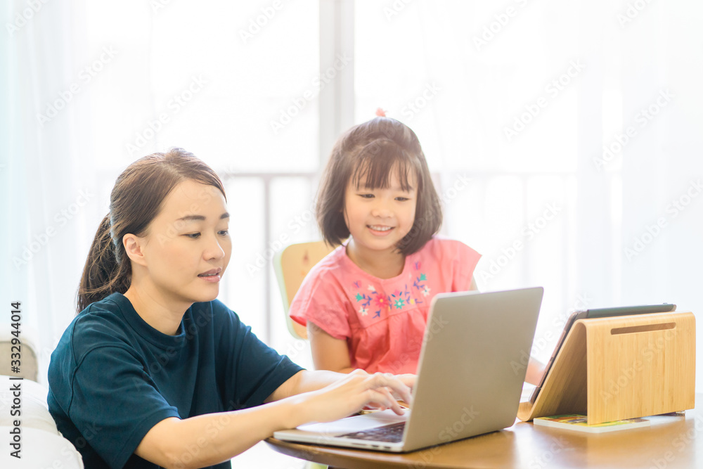 Covid-19 Coronavirus and Learning from home, Home school kid concept.Little asian girl study with online learning and asian mother work from home with laptop.Quarantine and Social distancing concept. Covid-19 Coronavirus and Learning from home, Home school kid concept.Little asian girl study with online learning and asian mother work from home with laptop.Quarantine and Social distancing concept.