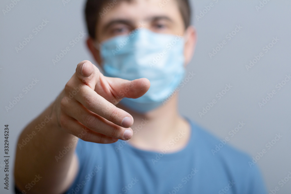 young man in a protective medical mask showing finger at you, quarantine measures control, doctor looking at you, concept of health and personal responsibility young man in a protective medical mask showing finger at you, quarantine measures control, doctor looking at you, concept of health and personal responsibility