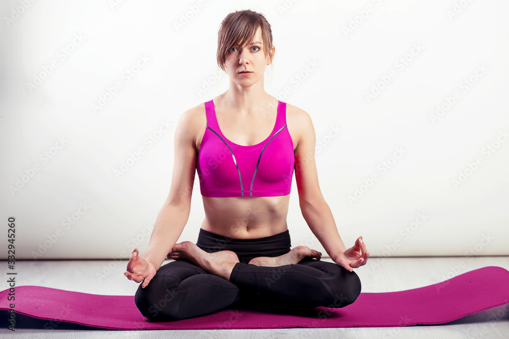Healthy living - woman meditating. Fitness woman practicing yoga in home. Enjoying peace and serenity in Lotus pose Healthy living - woman meditating. Fitness woman practicing yoga in home. Enjoying peace and serenity in Lotus pose
