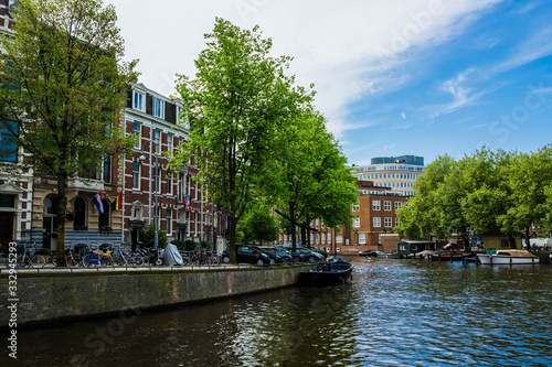 Cityscape of Amsterdam, Netherlands. Parking near the canal. Dutch urban architecture. Tourism in Europe.