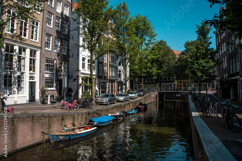 Cityscape of Amsterdam, Netherlands. Parking near the canal. Dutch urban architecture. Tourism in Europe.