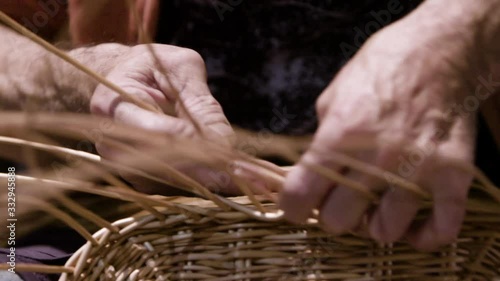 Local artisan hand weaving a wicker basket. Hands close up
