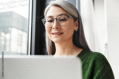 Attractive smiling mature woman with long gray hair standing Free Download Attractive smiling mature woman with long gray hair standing - GFXLoad