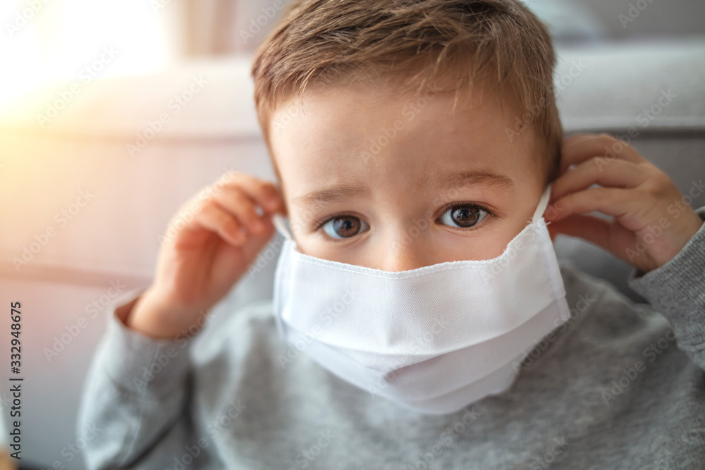 Little boy trying to stay healthy by wearing a mask to protect him against corona virus covid-19 / 2019-nCov. Little boy wearing anti virus mask staying at home Little boy trying to stay healthy by wearing a mask to protect him against corona virus covid-19 / 2019-nCov. Little boy wearing anti virus mask staying at home