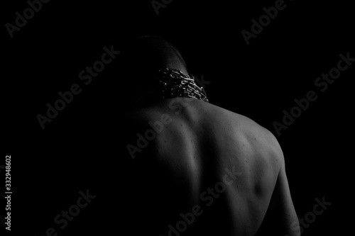 Back. The back of the man. Man holding a chain on his back in both hands. Chain. Black and white photo. Power. Sports Hall.