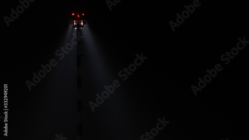 Light mast. Lighting at the airport. Light in the dark. Light beam in the fog on a black background.