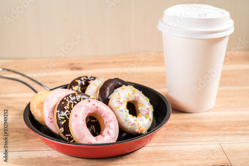 Donuts and drink and iron frying panon wood table background top view copy space pattern photo