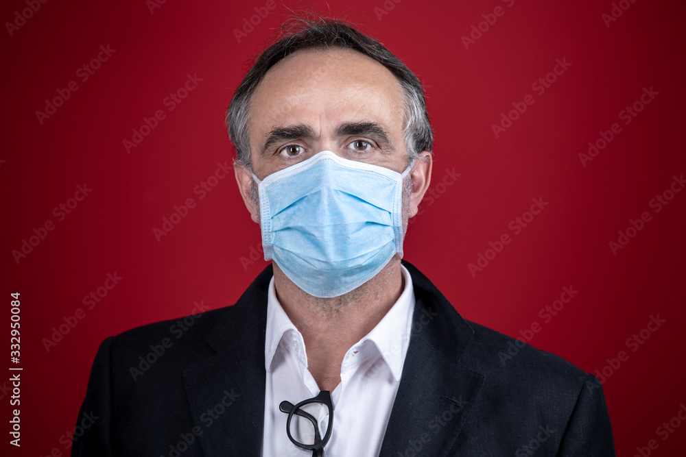 Manager in giacca e camicia indossa una mascherina isolato su sfondo rosso Manager in giacca e camicia indossa una mascherina isolato su sfondo rosso