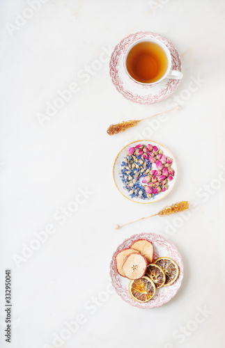 Cup of herbal tea with dried flowers and fruits.