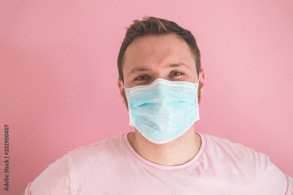 A man in a viral mask on a pink background, wearing face protection in prevention for coronavirus A man in a viral mask on a pink background, wearing face protection in prevention for coronavirus